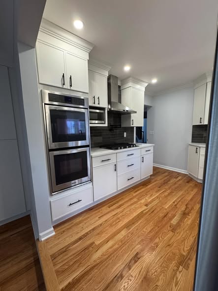 All-White Kitchen Cabinetry with Integrated Double Ovens &amp; Gas Cooktop