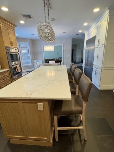 Mixed-Tone Kitchen Cabinetry with Built-In Appliances &amp; Marble Counters 
