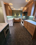 Warm Wood Kitchen Cabinetry with Green Backsplash & Quartz Counters
